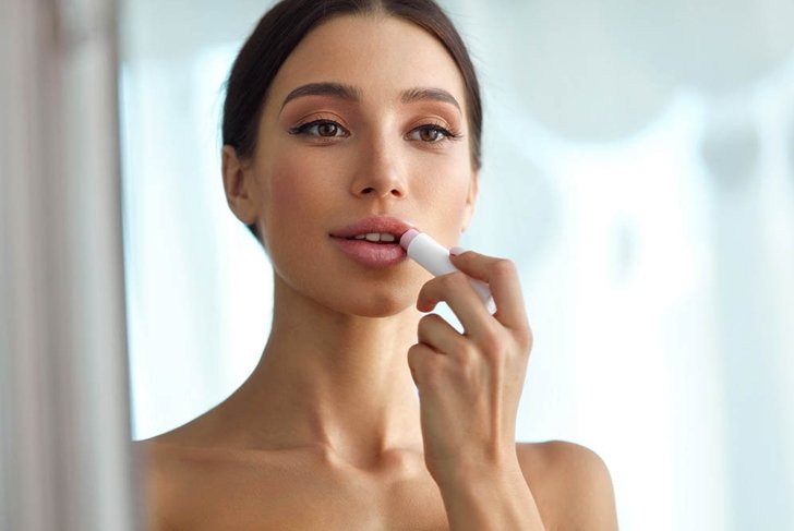 Lips Protection. Beautiful Woman With Beauty Face, Sexy Full Lips Applying Lip Balm, Lipcare Stick On. Portrait Of Female Model With Natural Makeup. Lips Skin Care Cosmetics Concept. High Resolution